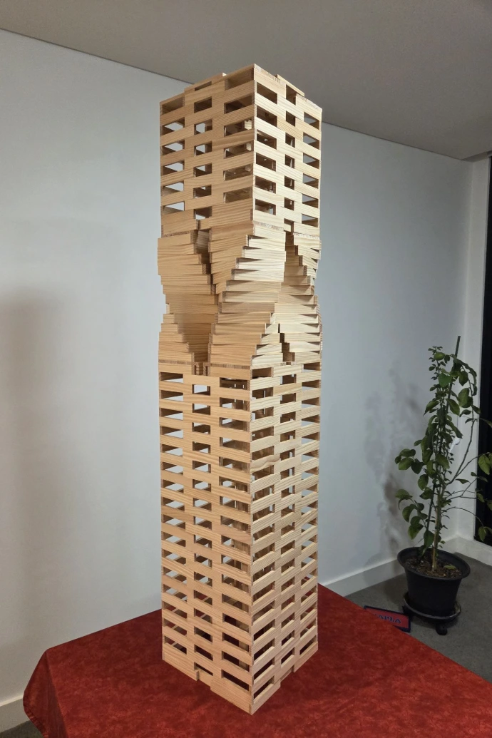 A tall, slender Kapla tower with a rotating mid-section, where each layer of wooden planks is slightly offset to create a spiral effect, mimicking the Karlatornet in Gothenburg.